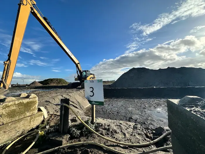 Graafmachine bij slibvak voor inname van schone, licht en zwaar verontreinigde bagger, zowel nat als droog.